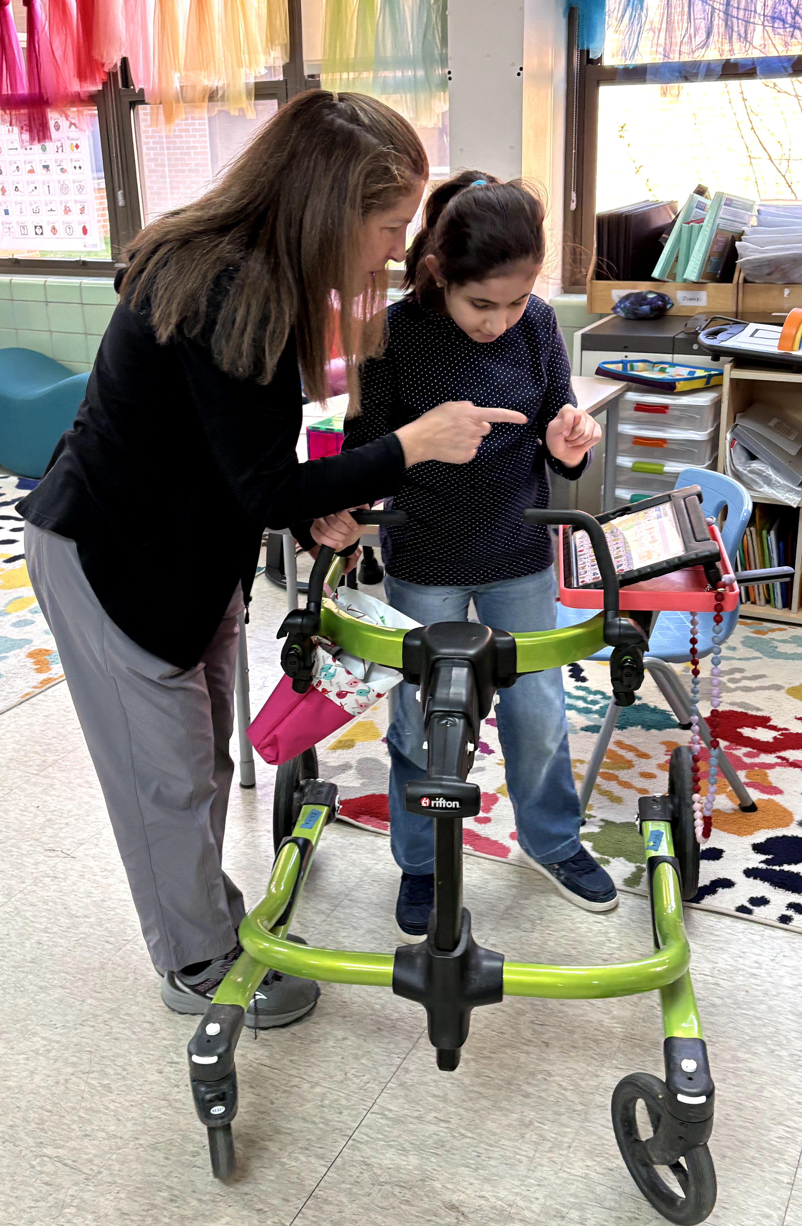 Physical therapist introducing the lunch tray holder to a student