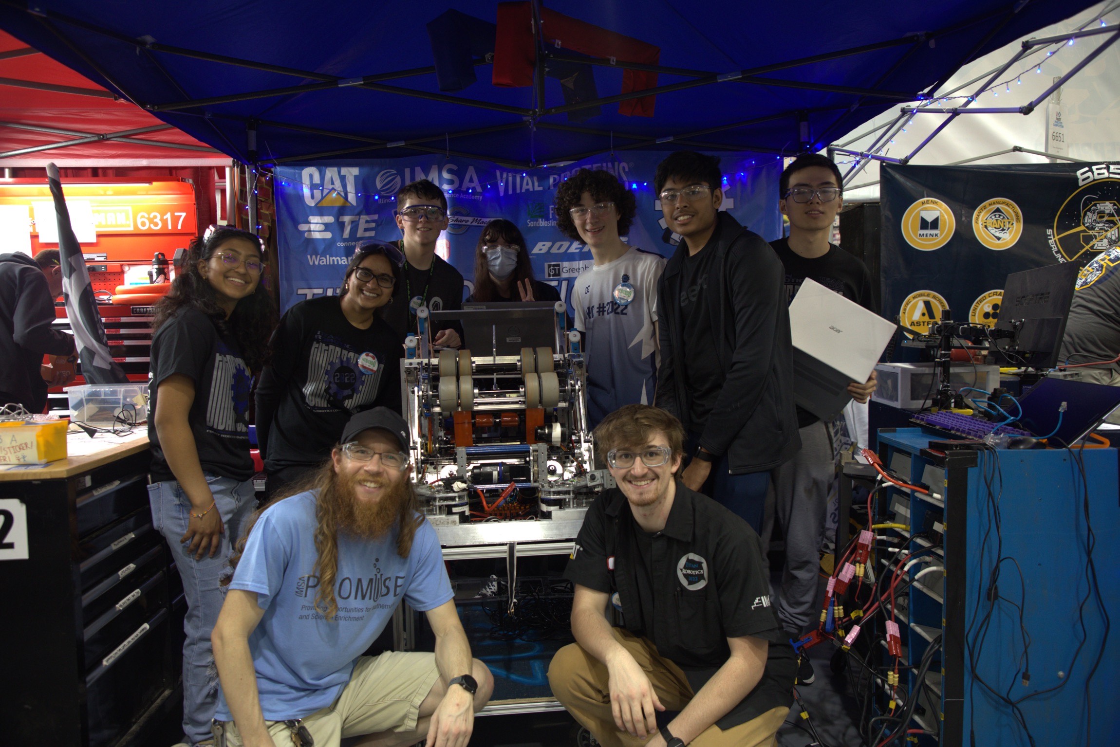 Team photo of pit crew at competition around the robot