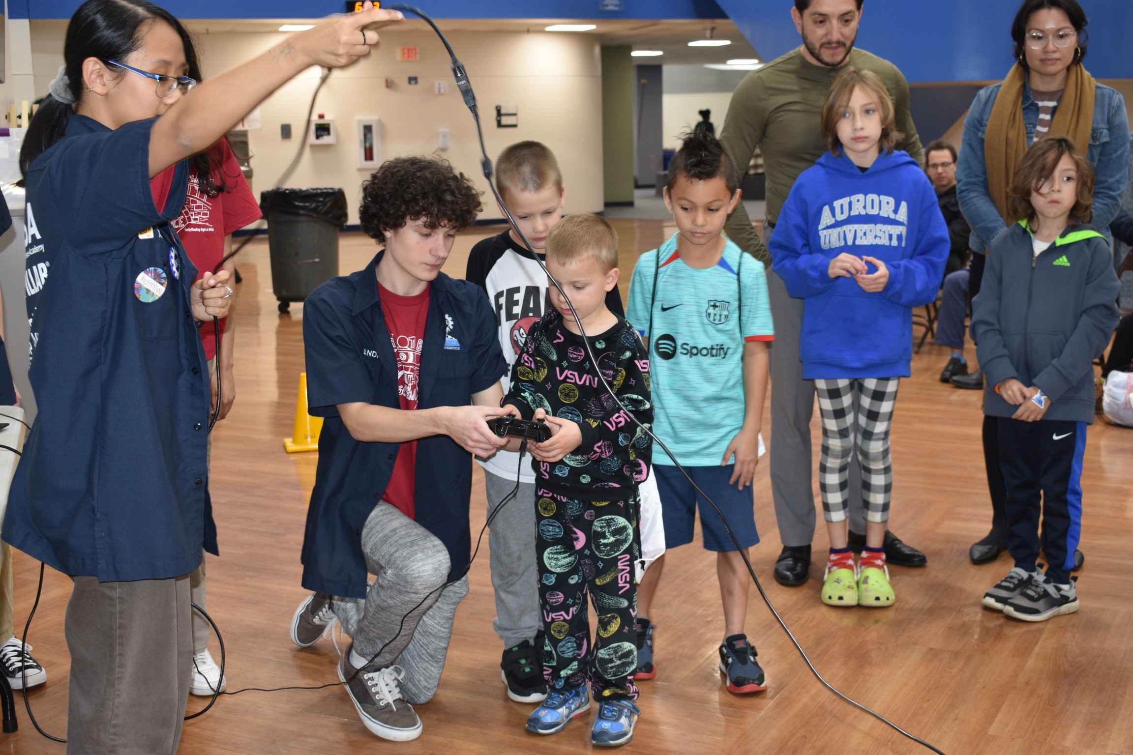 Nathan showing a child a controller and the robot during an outreach event